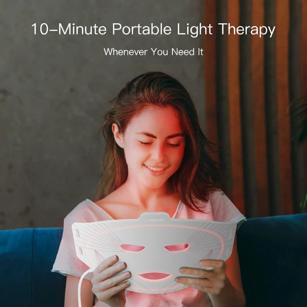 Woman using a 10-minute portable light therapy device on a couch.